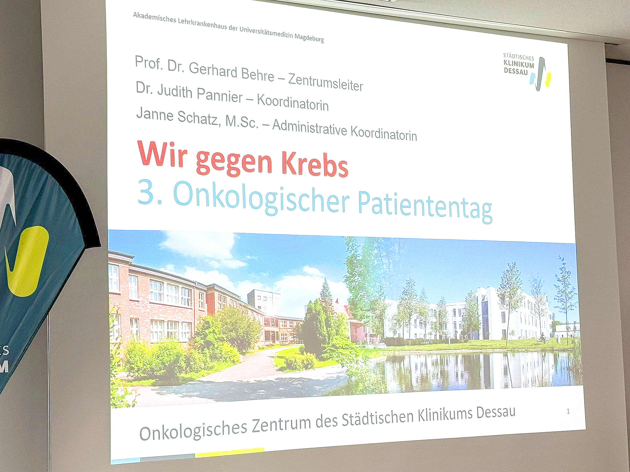Plakat zur Veranstaltung „3. Onkologischer Patiententag“ des Städtischen Klinikums Dessau mit dem Titel „Wir gegen Krebs“. Namentlich genannt werden Prof. Dr. Gerhard Behre als Zentrumsleiter, Dr. Judith Pannier als Koordinatorin und Janne Schatz, M.Sc., als administrative Koordinatorin.