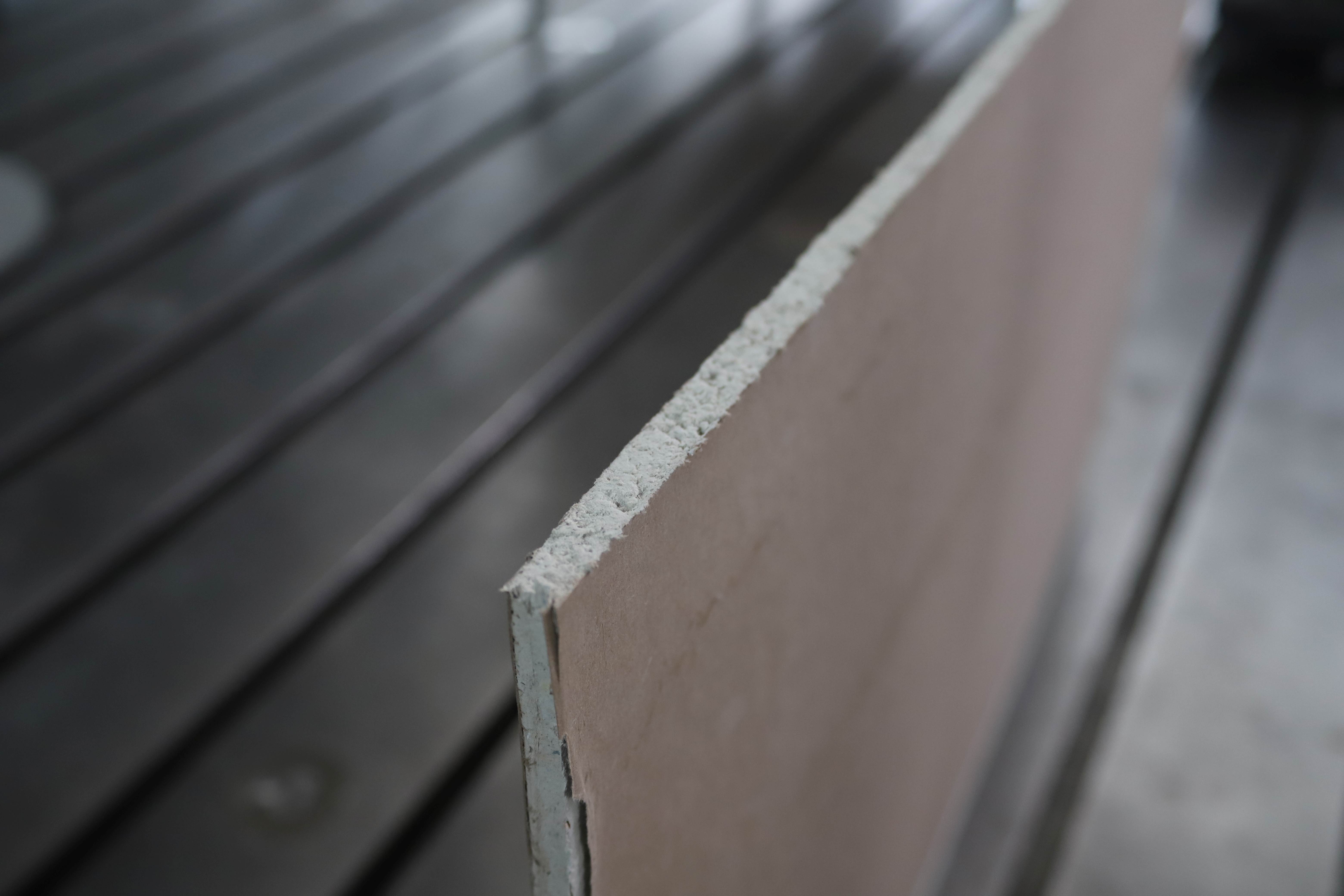 Foto mit strukturiertem grau-weißen Material in Form einer Platte in einem großen Raum weist auf Forschung zum Thema Kalkpappe als Gips-Alternative hin