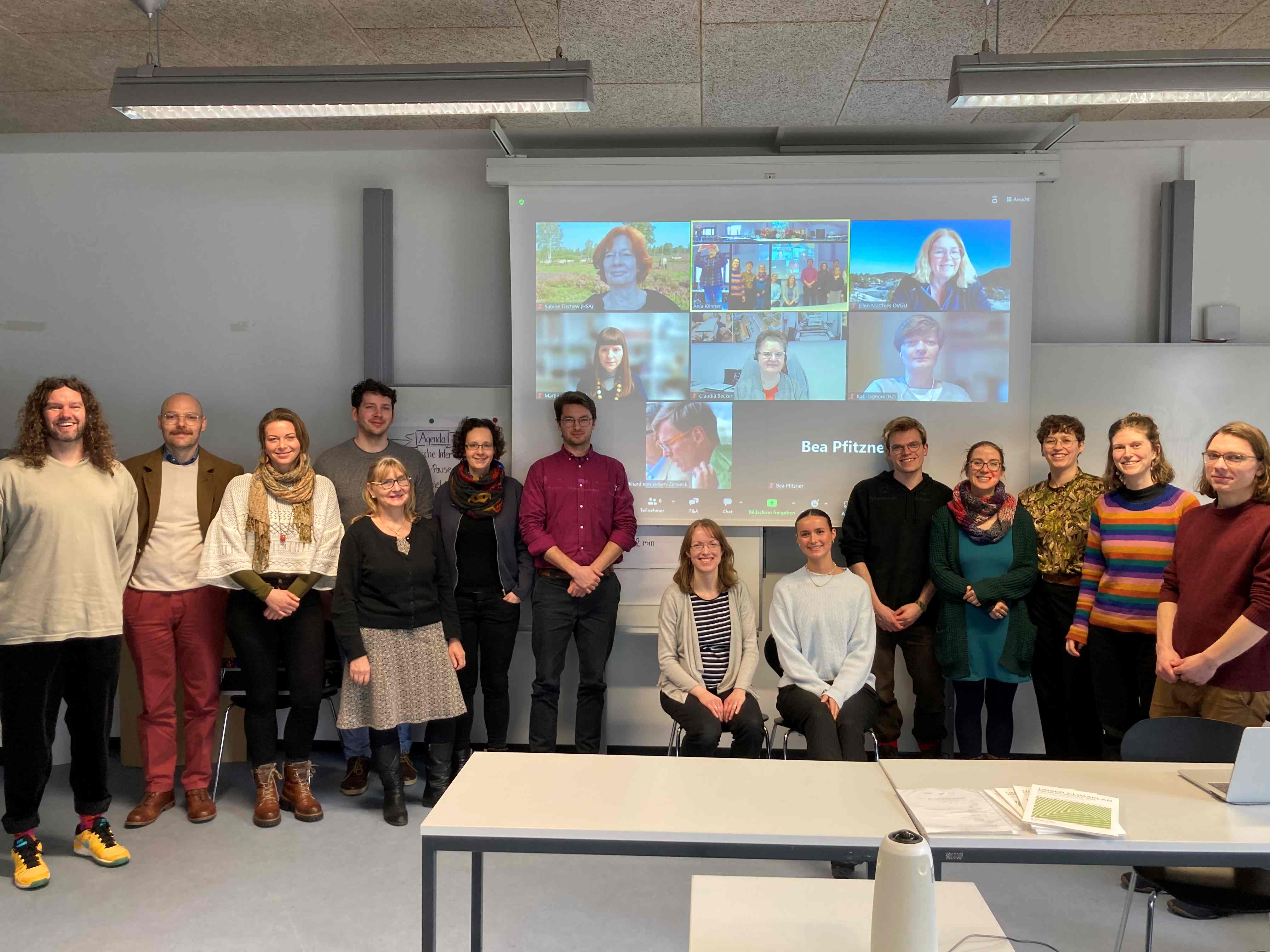 Gruppe von Personen vor einer Leinwand zeigt Team des Projekts KlimaPlanReal der Hochschulen Sachsen-Anhalts
