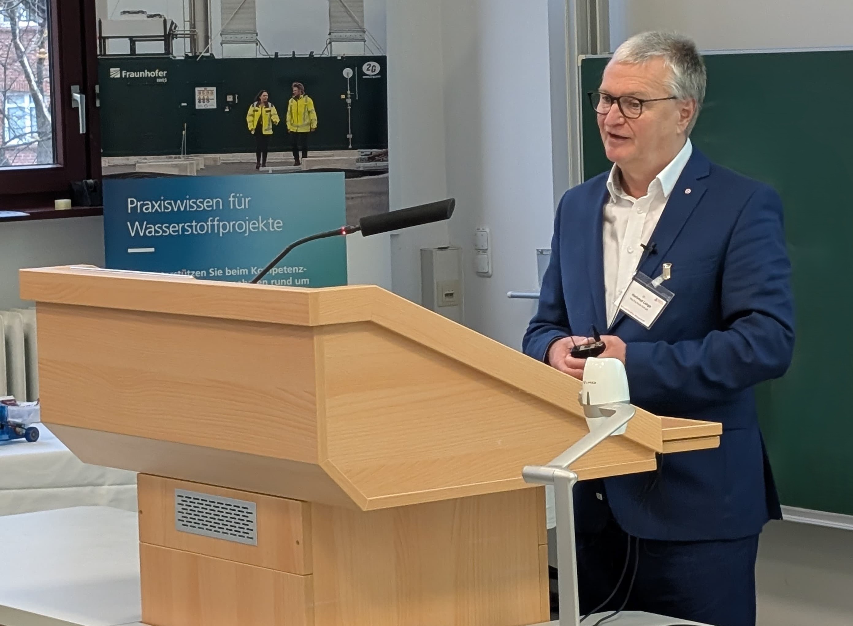 Person an einem Rednerpult zeigt Dr. Hartmut Lange vom Projekt H₂HUB im Weiterbildungszentrum (WZA) an der Hochschule Anhalt