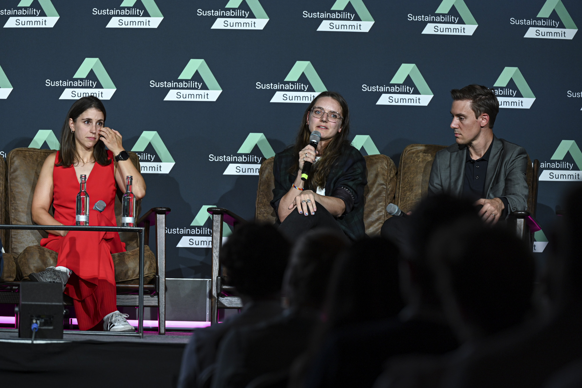Foto mit Person, die auf einer Bühne in einer Diskussionsrunde sitzt und mit dem Publikum spricht, zeigt die Promovendin Carolin Rautenberg von der Hochschule Anhalt