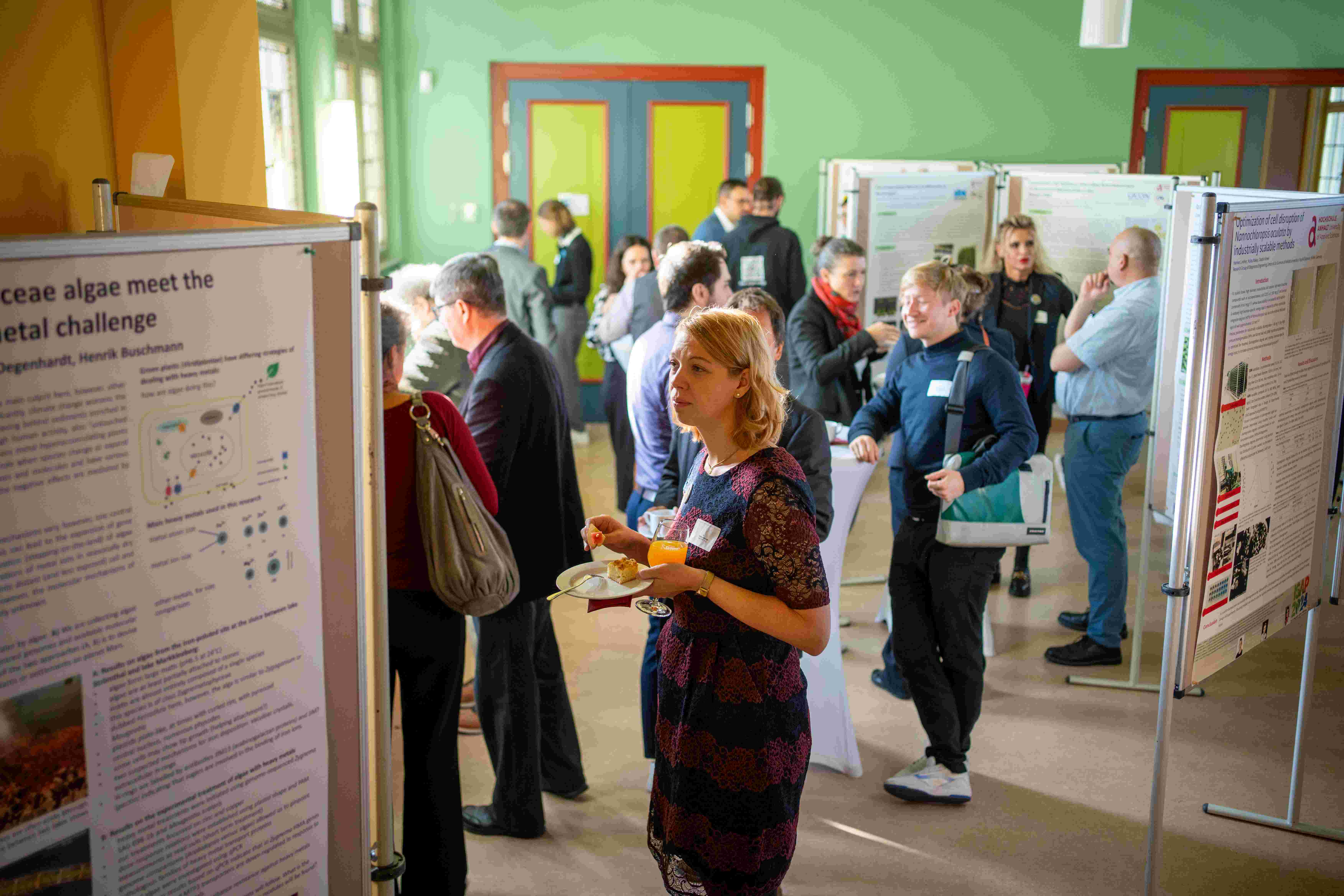 Foto mit Personen im Gespräch vor Posterpräsentationen zeigt Teilnehmende des Mitteldeutschen Algenstammtischs an der Hochschule Anhalt