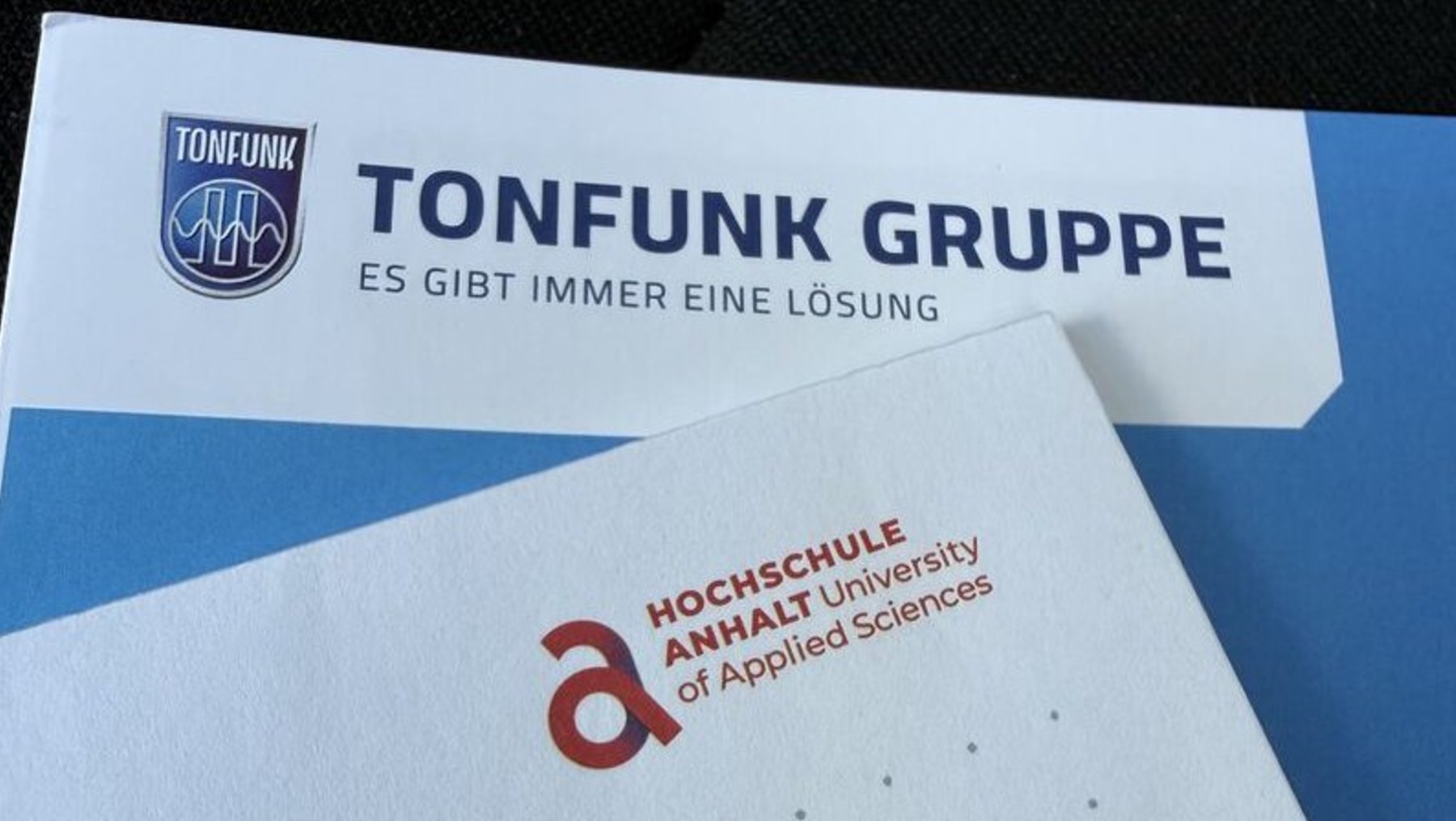 Ein weißes Blatt Papier mit der handschriftlichen Aufschrift „WERT STROM“ in Großbuchstaben, darunter das Logo der Hochschule Anhalt, University of Applied Sciences.