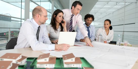 Büro-Angestellte besprechen einen Bauplan.