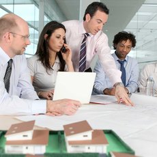 Büro-Angestellte besprechen einen Bauplan.