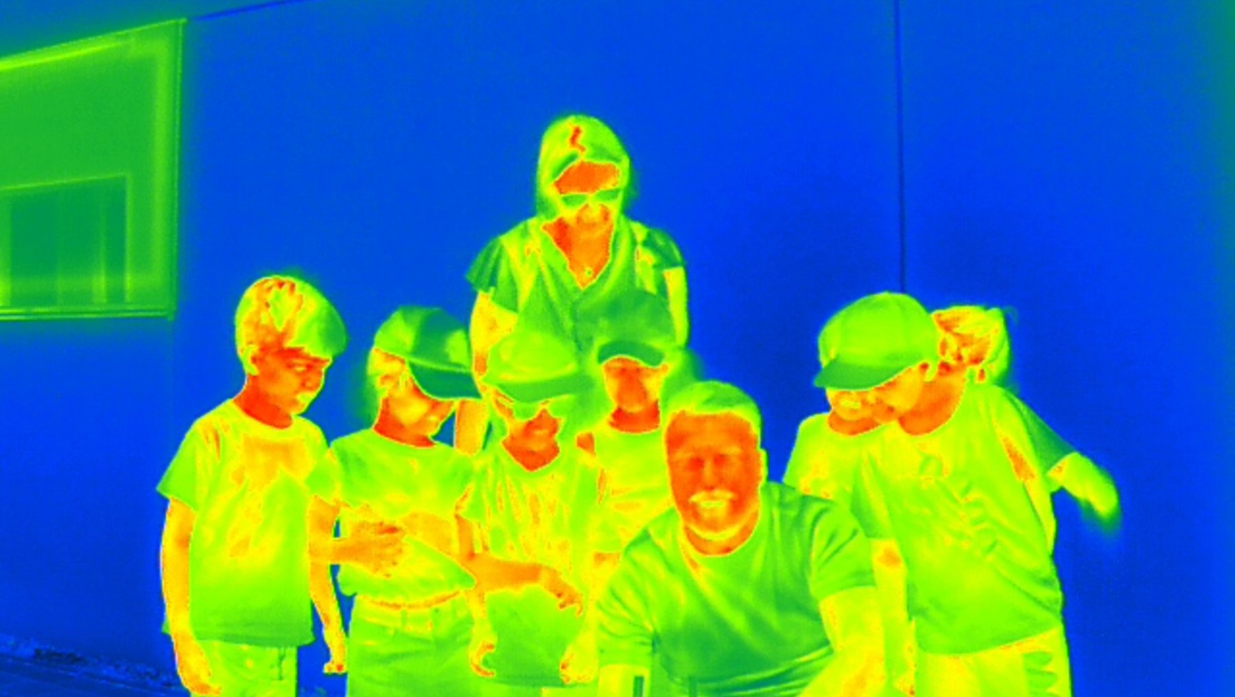 Gruppe von sieben Kindern und zwei Erwachsenen in Sportkleidung, die lächelnd zusammen posieren, vermutlich nach einer sportlichen Aktivität oder im Teamfoto.