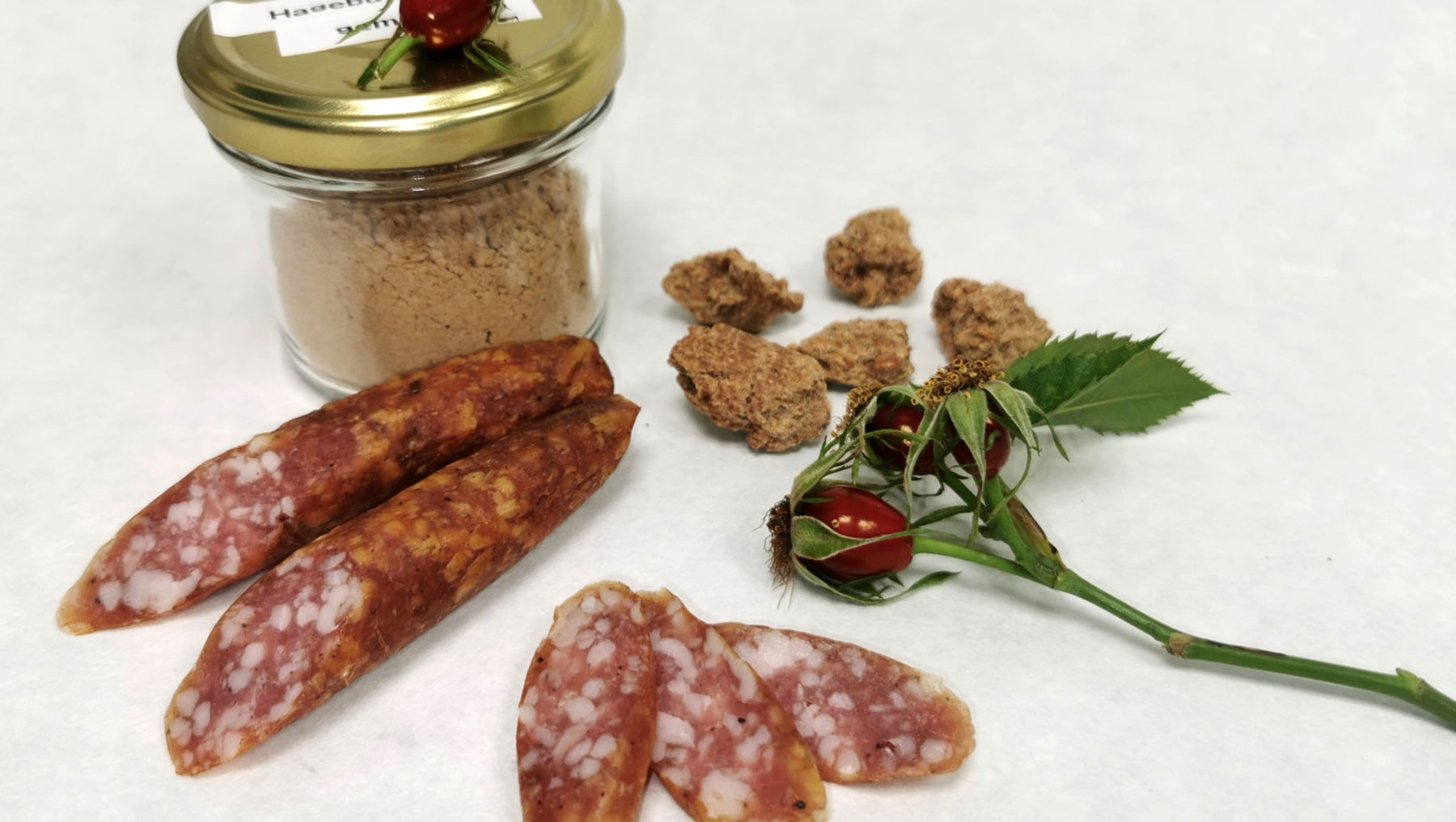Auf einem Tisch angerichtete Rohwurst mit Hagebuttentrestermehl