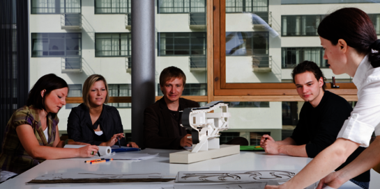 Gruppenarbeit von Studierenden an einem Architekturmodell