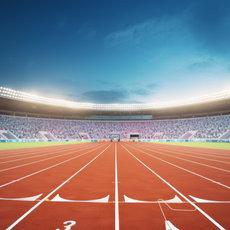 Großer, beleuchteter Leichtathletikstadionplatz mit roter Tartanbahn, umgeben von dicht besetzten Zuschauerrängen unter Abendhimmel.