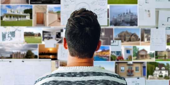 Studierender schaut eine Foto-Pin-Wand an