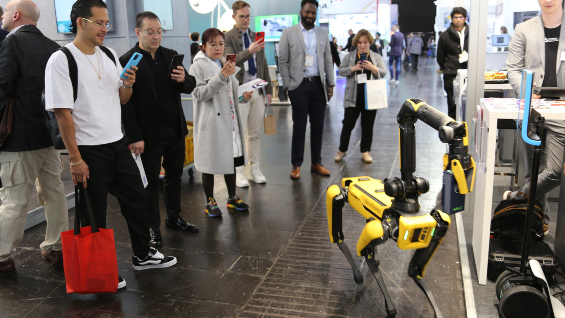 Eine Gruppe von Messebesuchern schaut sich den Roboterhund Spot an.