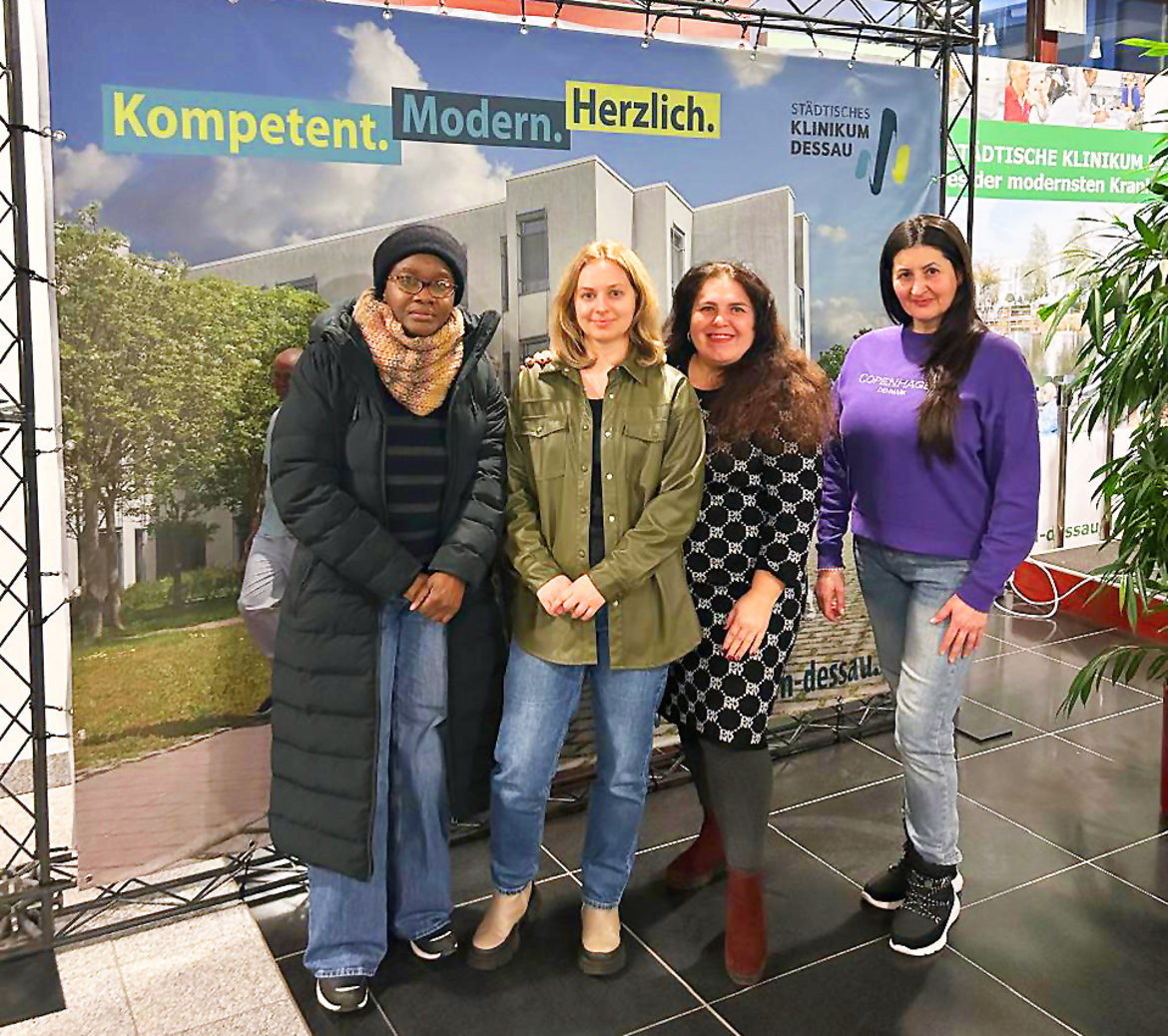 Vier lächelnde Personen stehen gemeinsam vor einer informativenementation für „Städtischen Klinikum Dessau“.

Die Beschilderung mit den Worten „Kompetent. Modern. Herzlich.“ ist erkennbar; vermutlich handfält es sich hier um eine Veranstaltung oder Vorstellung bezüglich des Klinikums.