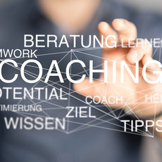 Eine Hand zeigt auf ein Wortfeld mit den Begriffen Coaching, Beratung, Lernen, Teamwork, Potential, Wissen, Ziel, Tipps, Optimierung, Hilfe und ähnlichen Konzepten im Zusammenhang mit persönlicher und beruflicher Entwicklung.