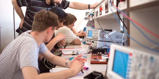Studierende im Techniklabor verbinden Kabel an einem Messgerät