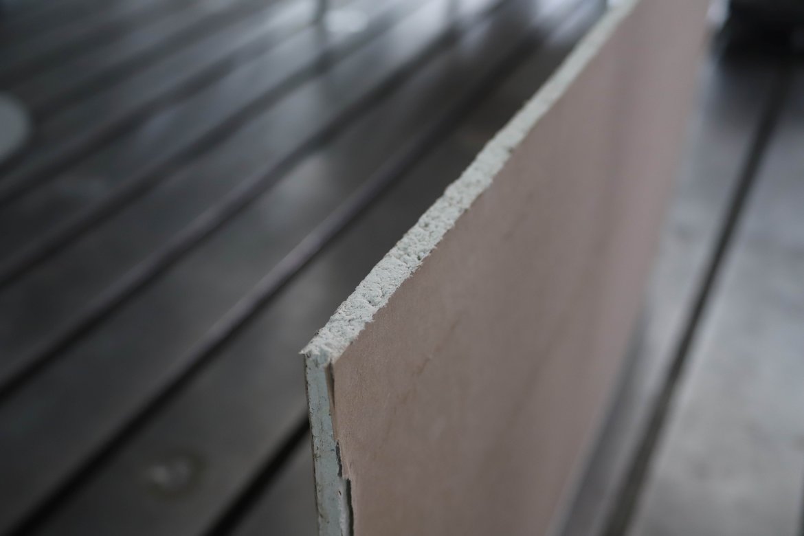 Foto mit strukturiertem grau-weißen Material in Form einer Platte in einem großen Raum weist auf Forschung zum Thema Kalkpappe als Gips-Alternative hin