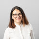 Diese Abbildung zeigt eine lächelnde Person mit braunen Haaren und einer Brille, die ein weißes Gestrick oder eine Bluse trägt.

Alternative Bildbeschreibung: Portrait einer Frau mitouvoirvollem Lächeln, Brauen, Tragender Brille und weißem Oberteil.
