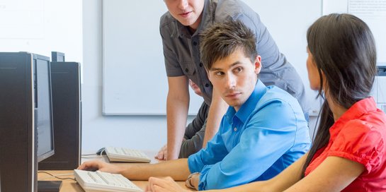 Drei Studierende vorm PC