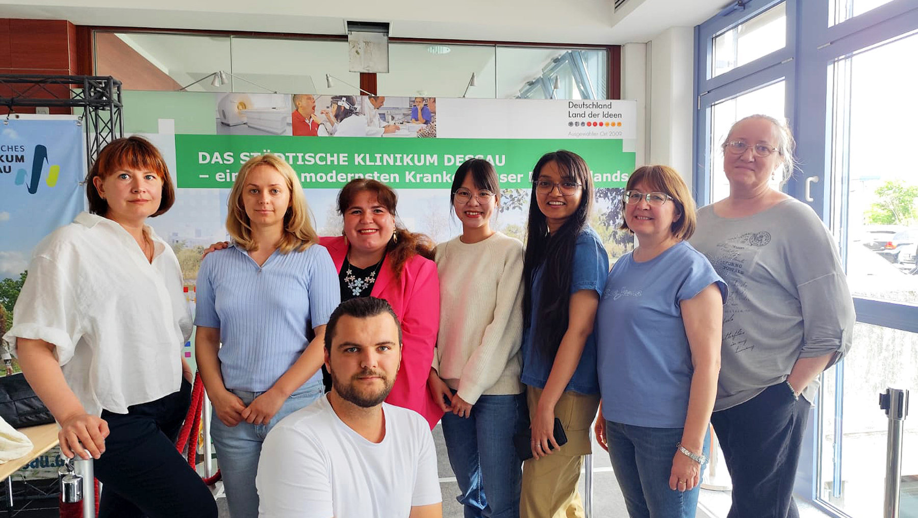 Gruppe von sieben Personen, darunter fünf Frauen und zwei Männer, stehen lächelnd vor einem Banner mit der Aufschrift *„Das statistische Klinikum Detmold – ein modernes Krankenhaus in der Region“*.