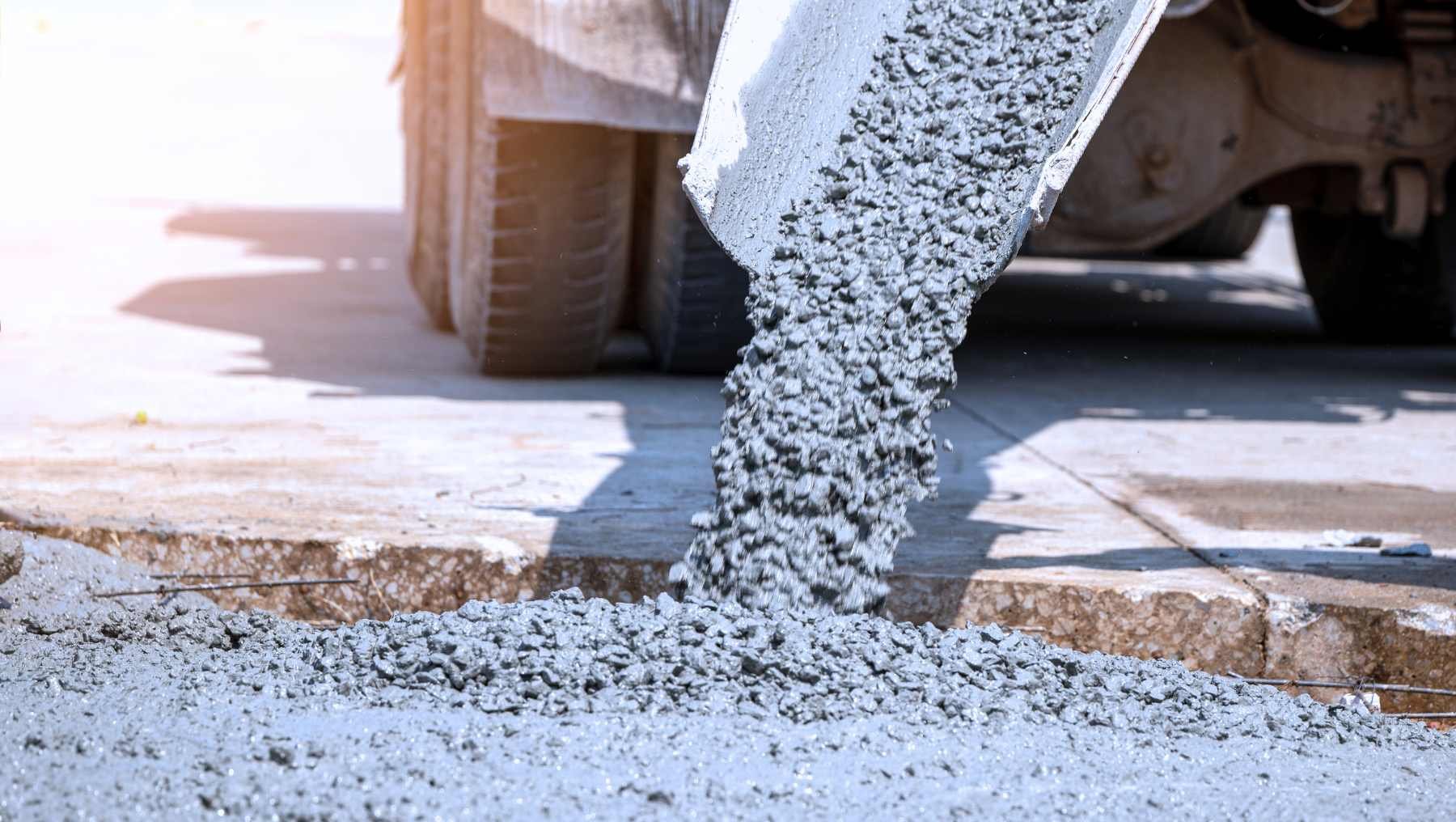 Symbolbild für das Thema nachhaltiger Beton zeigt, wie Beton von einem Laster auf die Straße rutscht