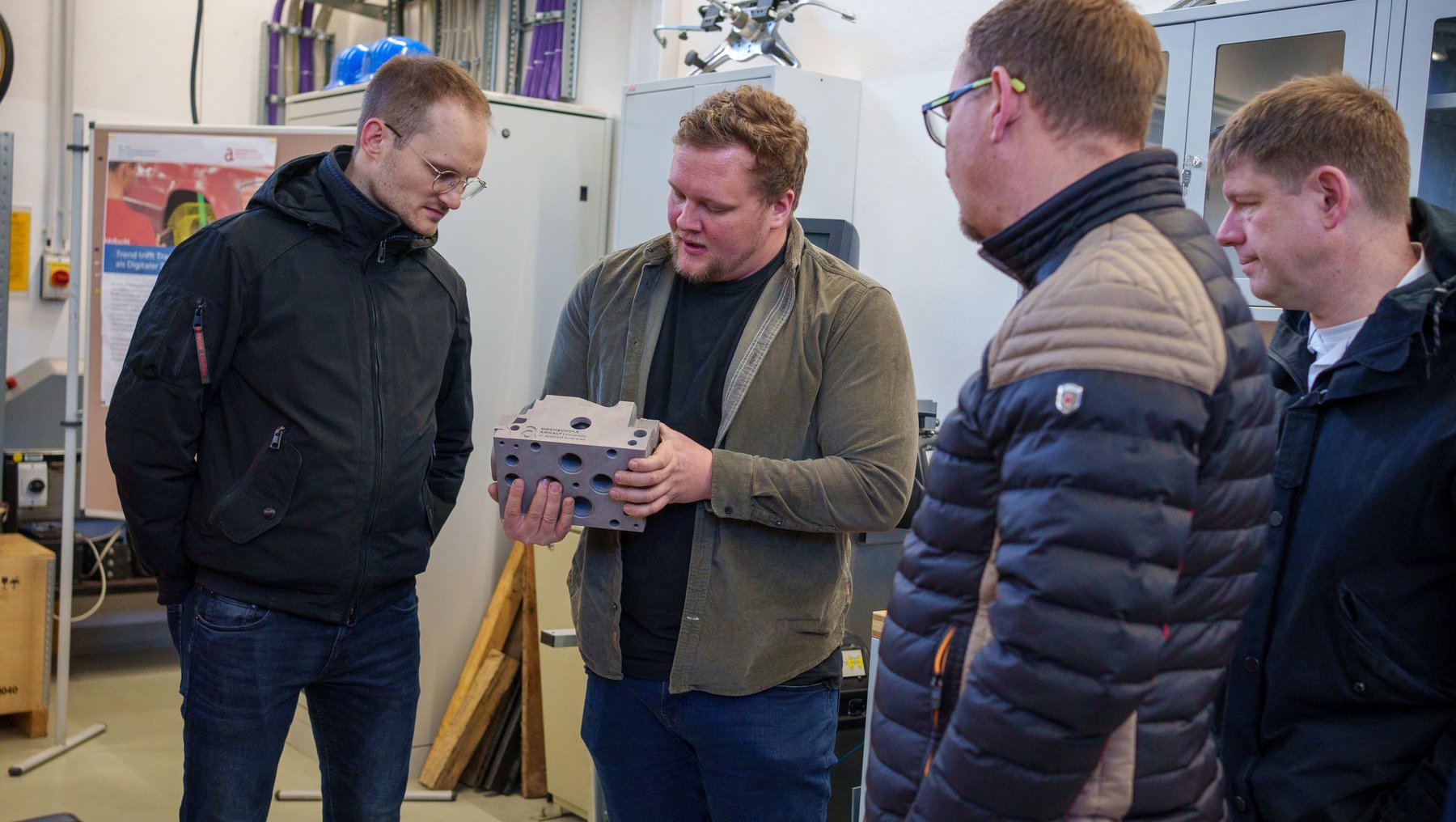Teilnehmer der VDI Fachausschusstagung in der Fahrzeugtechnik. Herr Täger erläutert ein Bauteil.