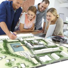 Studierende arbeiten an einem Lageplan mit Bäumen und Häusern