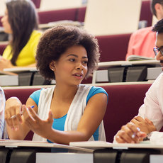 Studierende diskutieren im Hörsaal