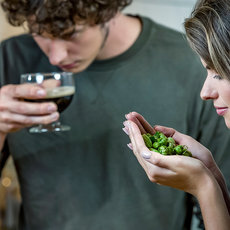 Zwei Menschen sitzen zusammen und genießen ein gemeinsames Essen.
Der Mann hält ein Glas Rotwein, die Frau ein Stückchen mit Spinat-Grüntönen.
Beide scheinen entspannt und genießen gemeinsam ein Mahl.