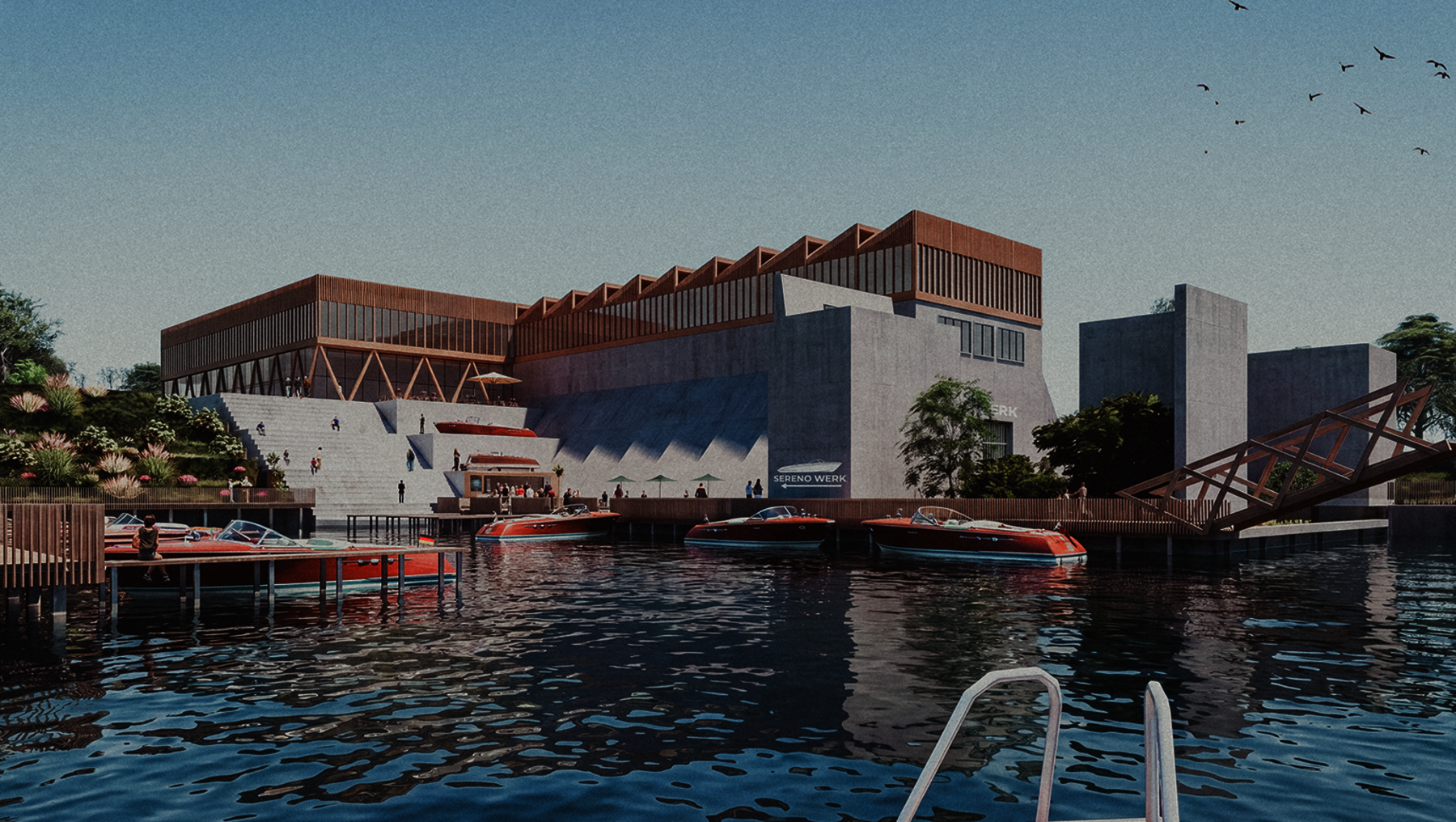 Moderne Industriearchitektur am Wasser mit mehreren Gebäuden in hellen und roten Tönen, darunter ein großes, flaches Dachgebäude und ein Turm. Im Vordergrund ein Boot auf ruhigem Gewässer, im Hintergrund Bäume und ein Steg.