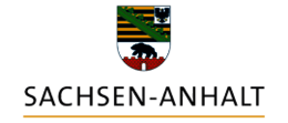 The image displays the emblem of the German state of Saxony-Anhalt. The emblem features a shield with horizontal stripes in various colors, including green, black, and white, and a black bear in the center. Below the emblem, the text "SACHSEN-ANHALT" is written in capital letters.