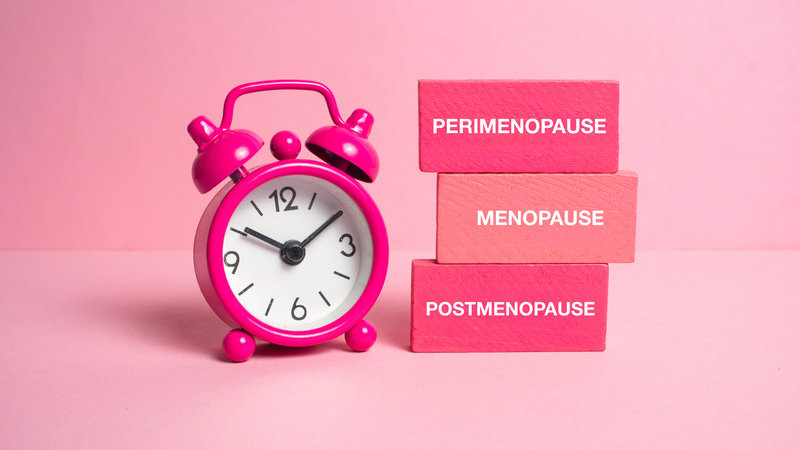 Wecker auf 3 Uhr zeigt die drei Phasen der Menopause an: Perimenopause, Menopause und Postmenopause als aufsteigende Stufen.